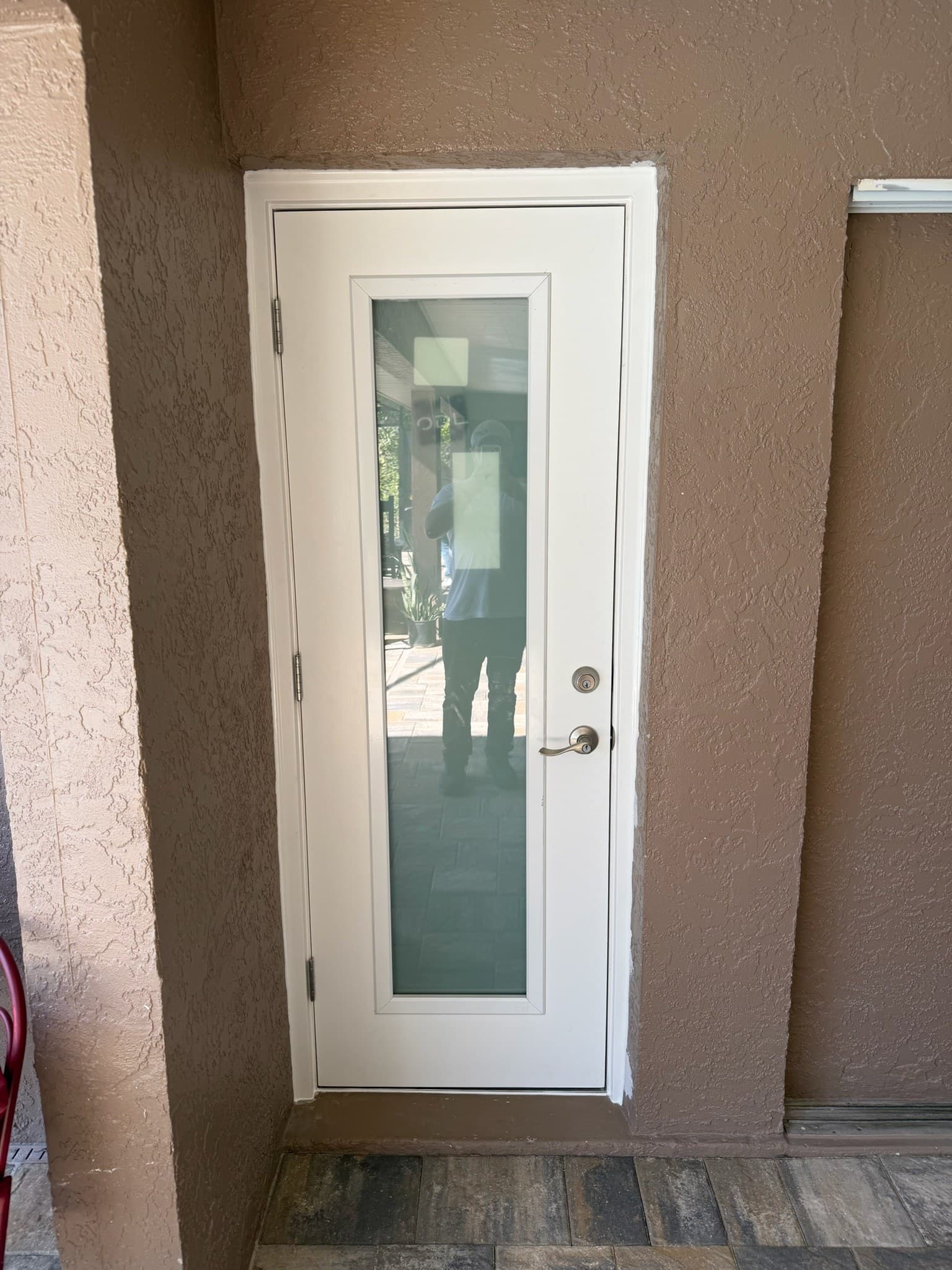 A door with black lever hardware, set in a stucco wall