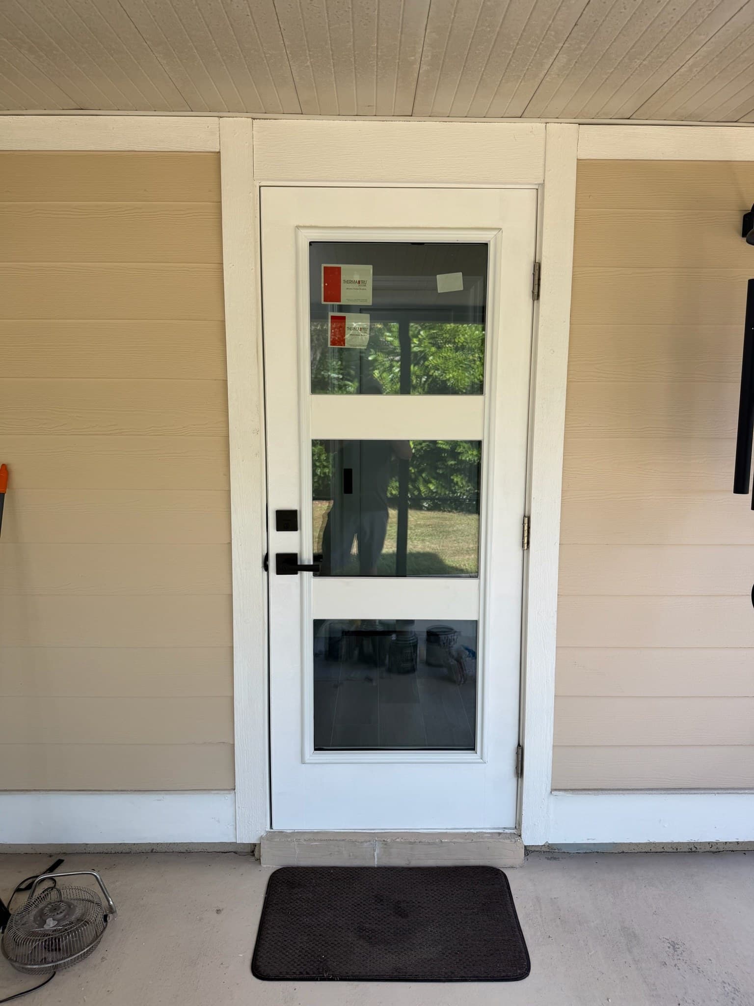 A white front door on a covered porch