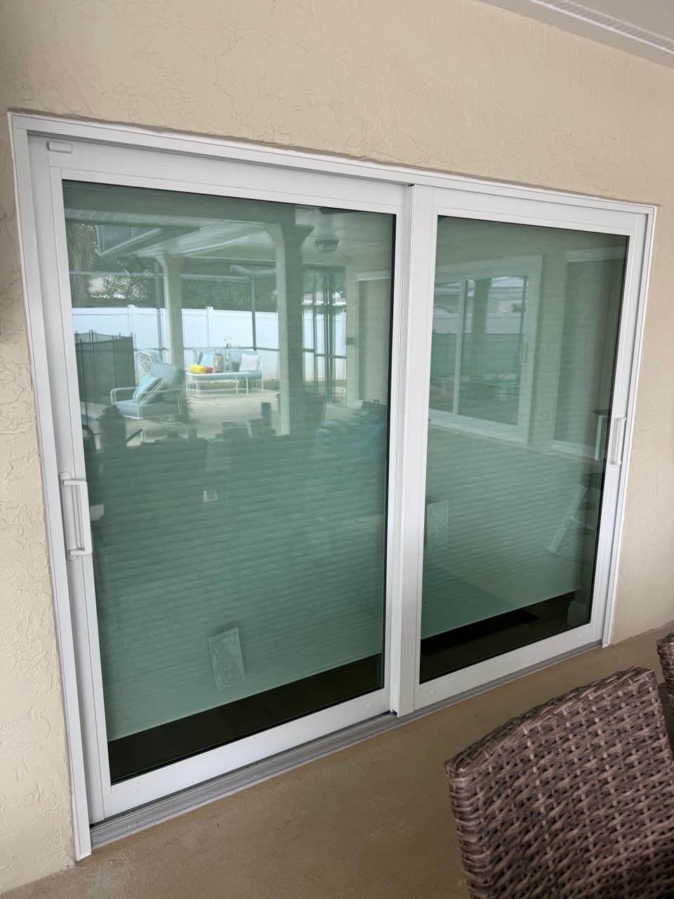 A two-panel white sliding patio door closed in its frame, the weatherstrip seated along the meeting stile