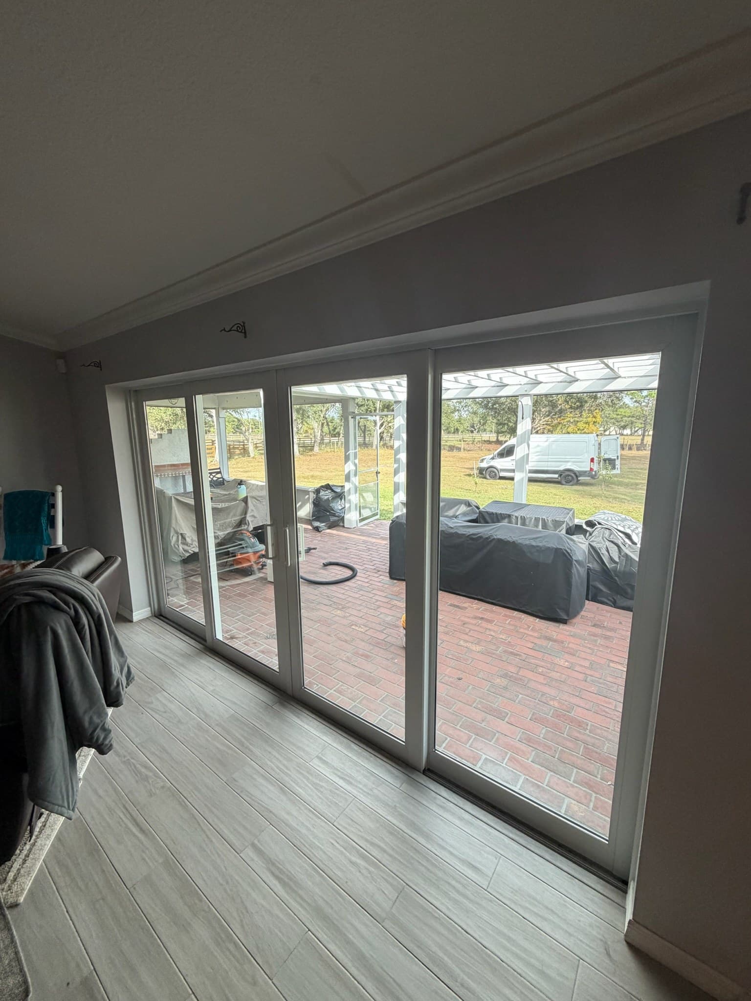 A white multi-panel sliding patio door opening onto a brick patio