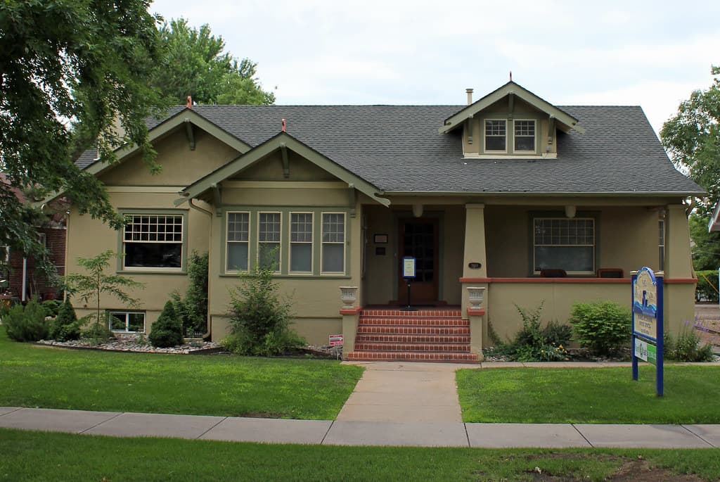 A craftsman-style bungalow with a covered front porch and a dormer window in the roof