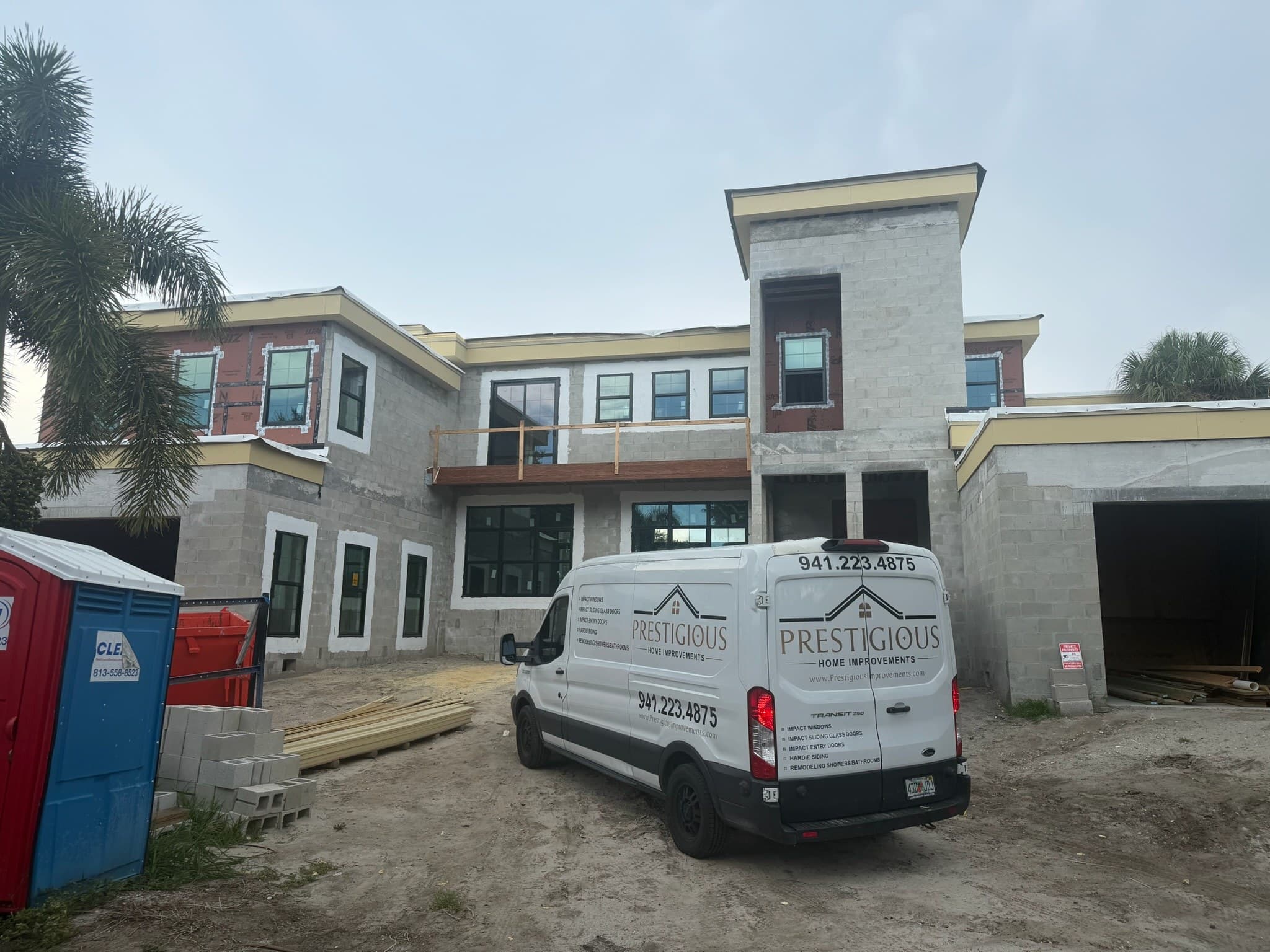 A work van parked at a residential job site during window installation