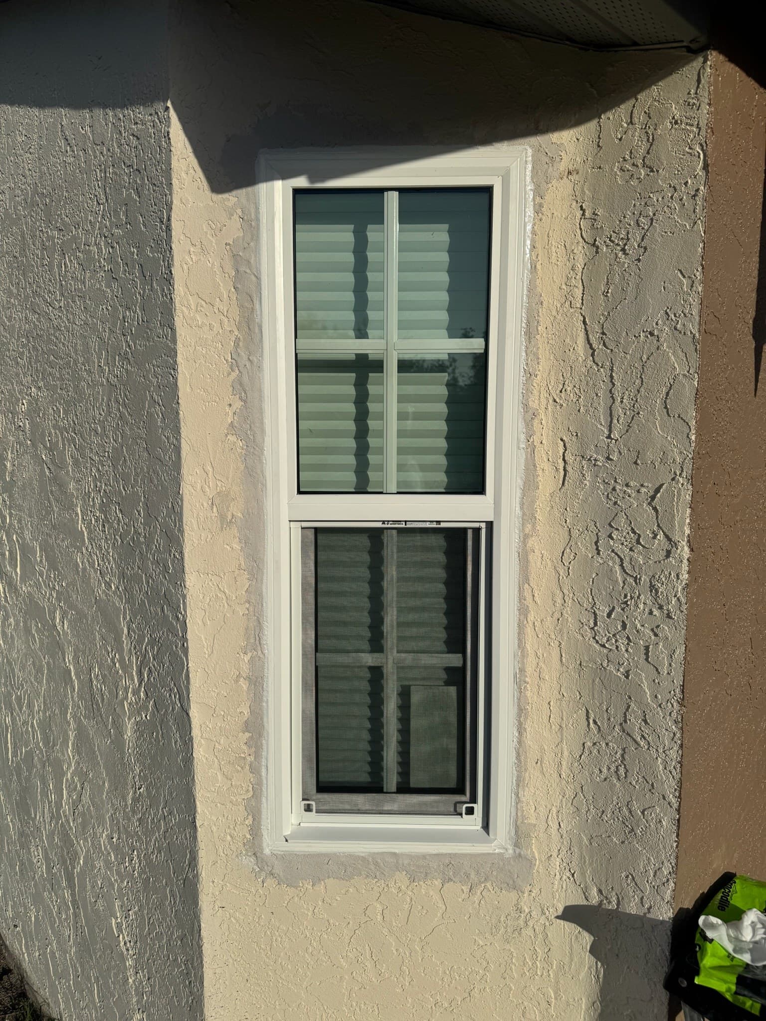 A newly installed double-hung window, trimmed and caulked