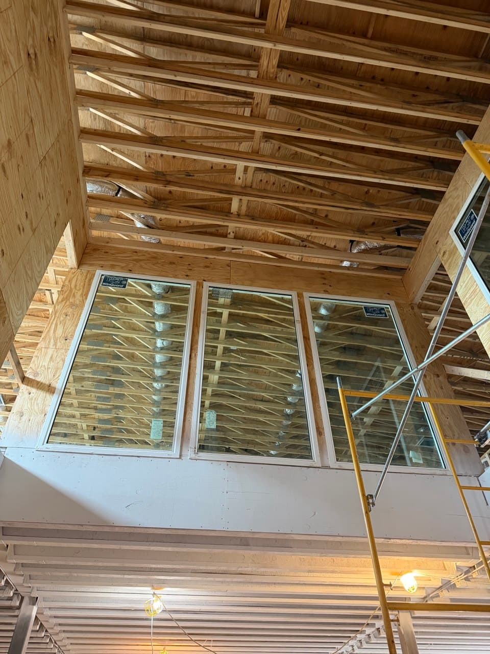 Newly installed windows set high in a gable wall, photographed before the ceiling was closed in