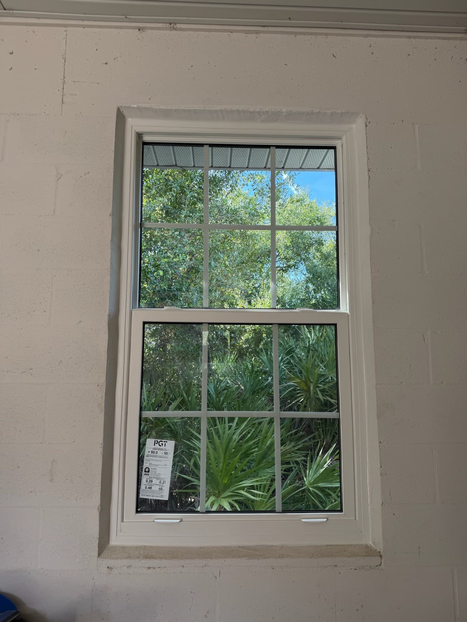 A newly installed window with the manufacturer's spec sticker still on the glass